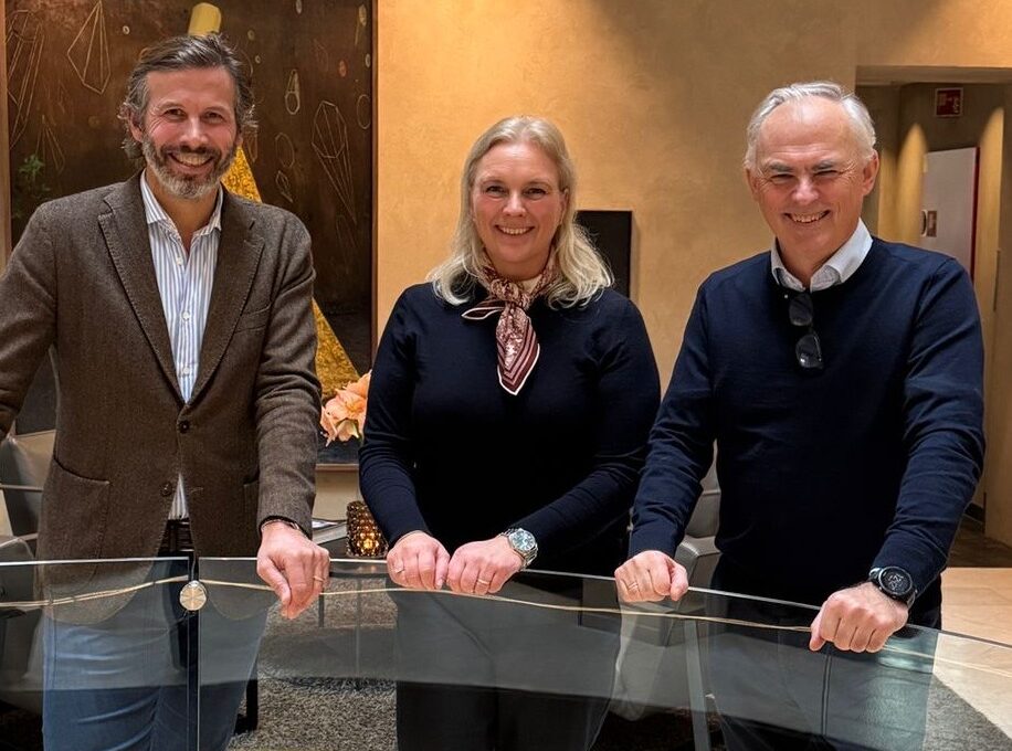 En kvinna och två män som ler mot kameran.